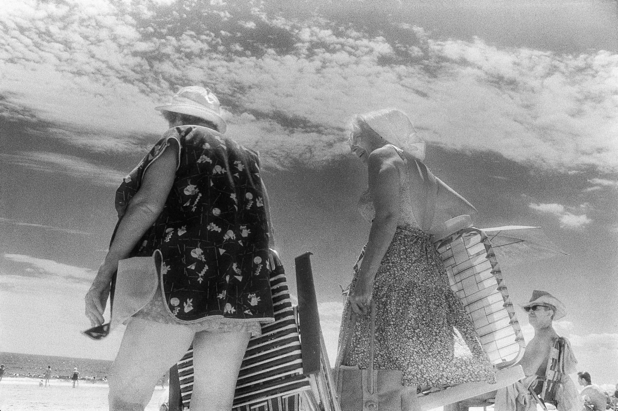 Barbara Alper- Photo of two women walking on sand  Rockaway Beach NYC