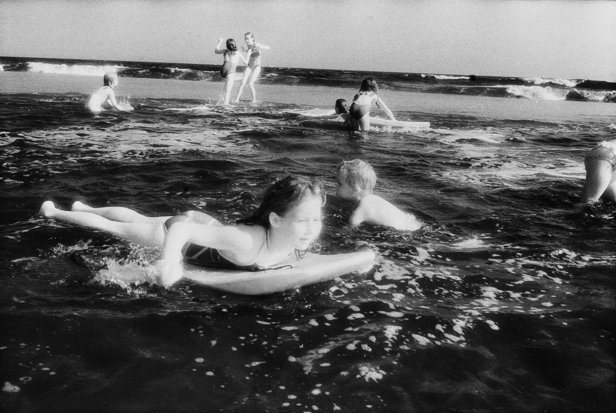 Barbara Alper- photo of kids body surfing in the water at Rockaway Beach NYC