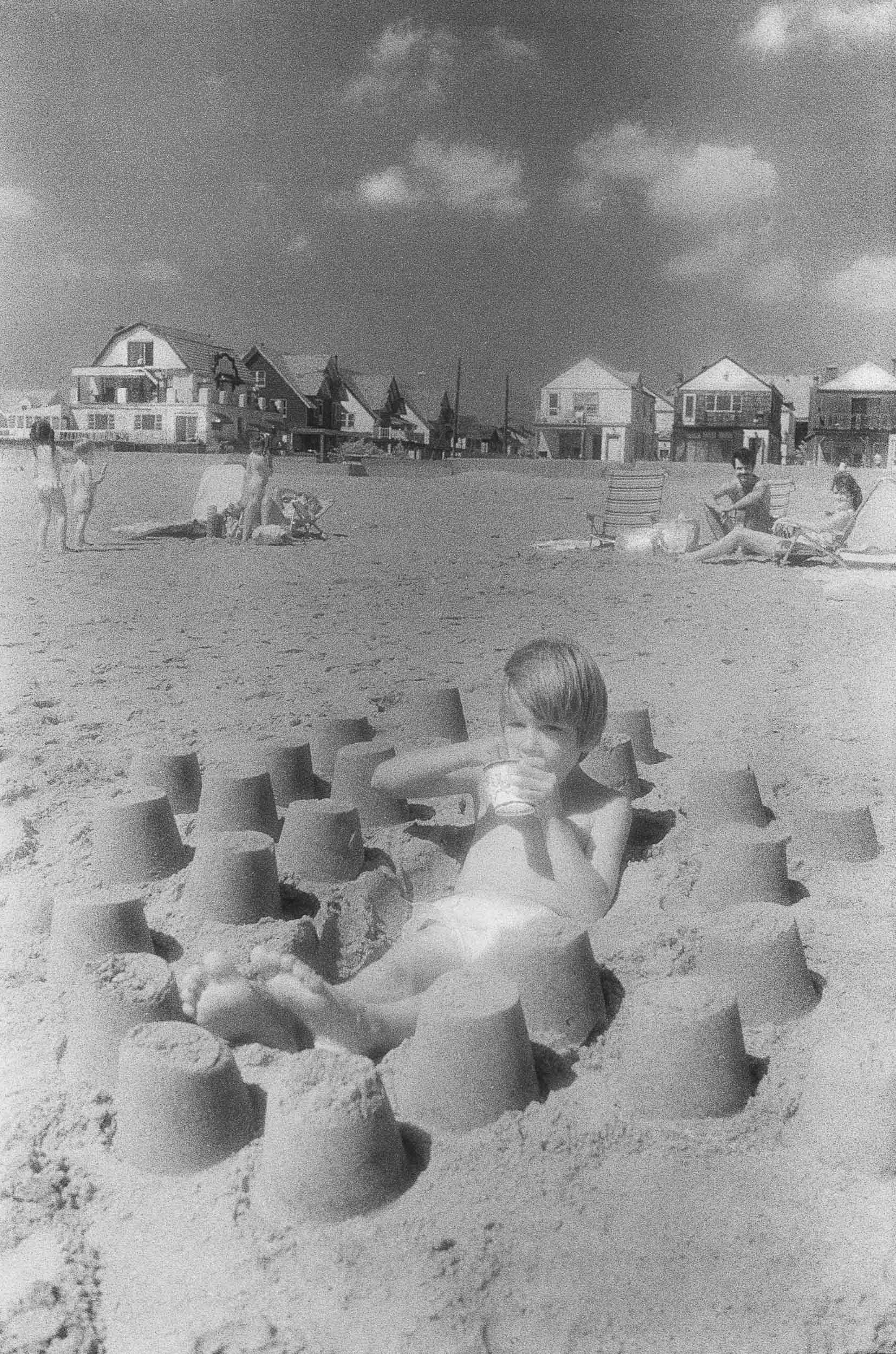 Barbara Alper- Photo of a boy building sand castle at Rockaway Beach NYC
