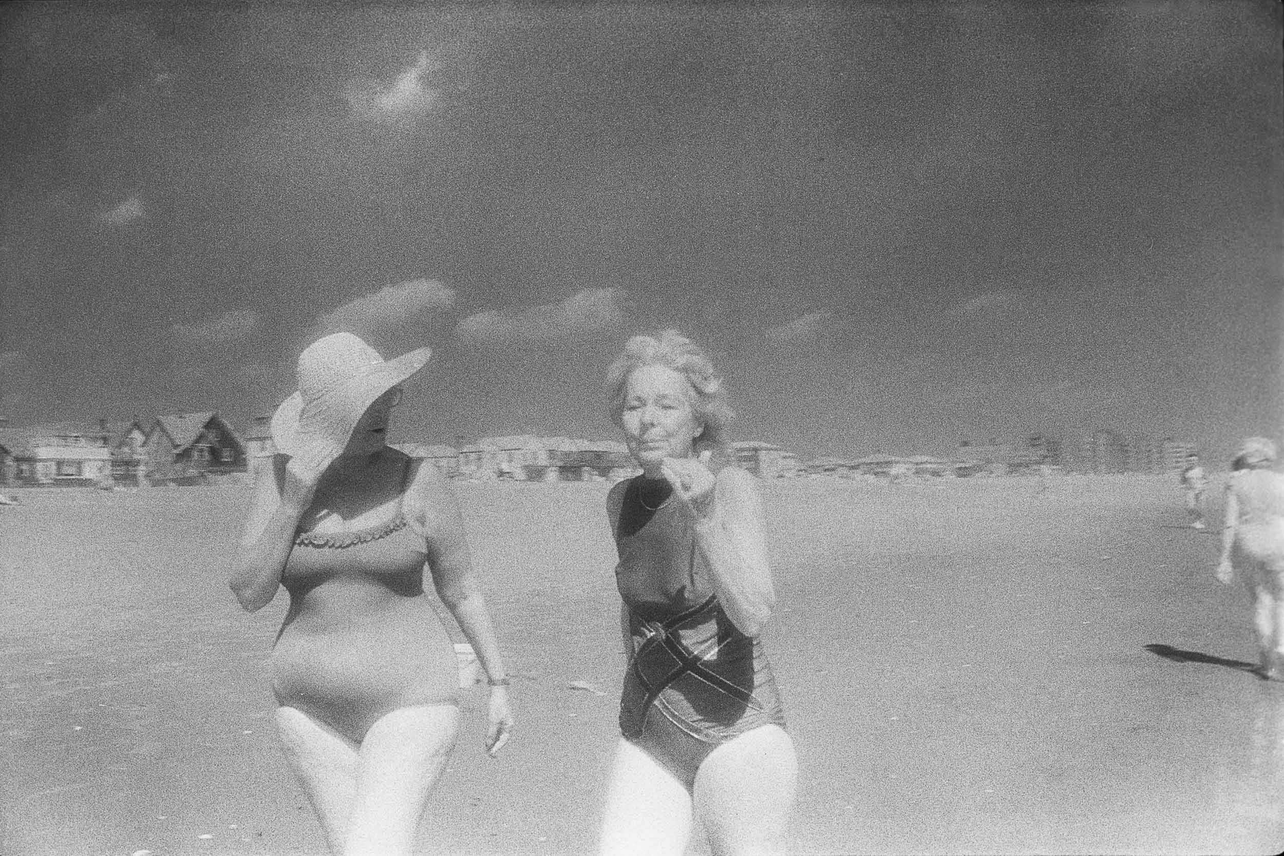 Barbara Alper- Photo of women walking and talking together on Rockaway Beach NYC